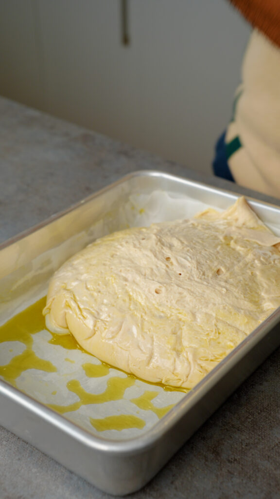 transferring focaccia dough into tin