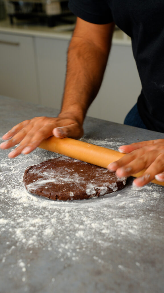 rolling out chocolate pastry dough with a rolling pin