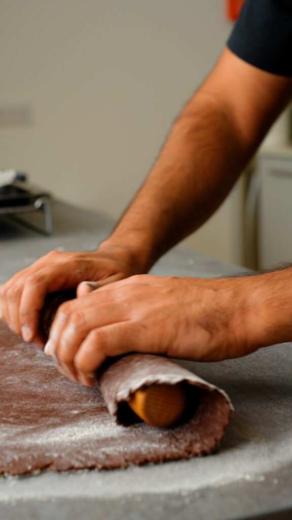 rolling chocolate pastry dough around a rolling pin