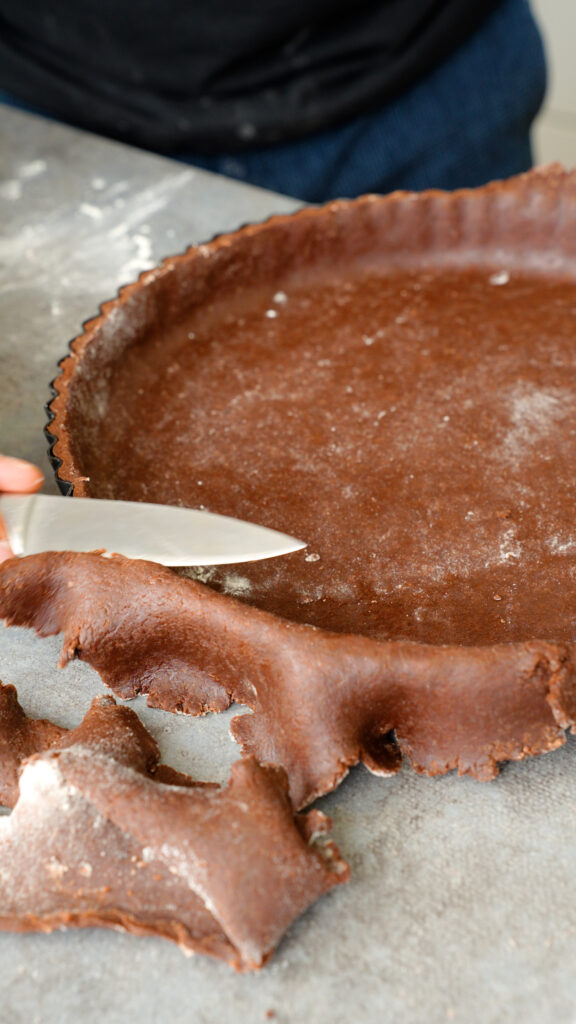 pressing pastry dough in and trimming off excess