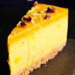 baked mango lassi cheesecake sliced and served on a plate