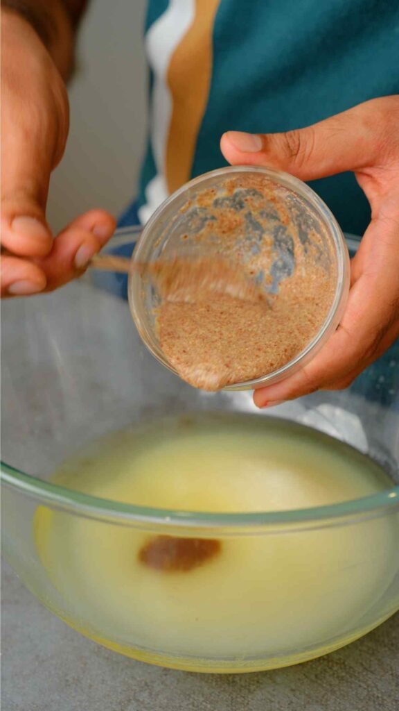 ground flaxseeds mixed with water being added to the mixing bowl