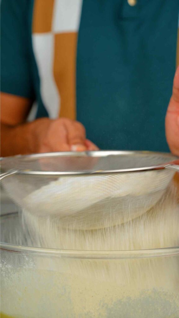 sifting in flour, baking powder, and salt into the mixing bowl