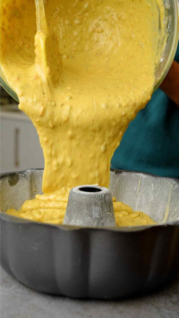 pouring pistachio sponge into bundt tin