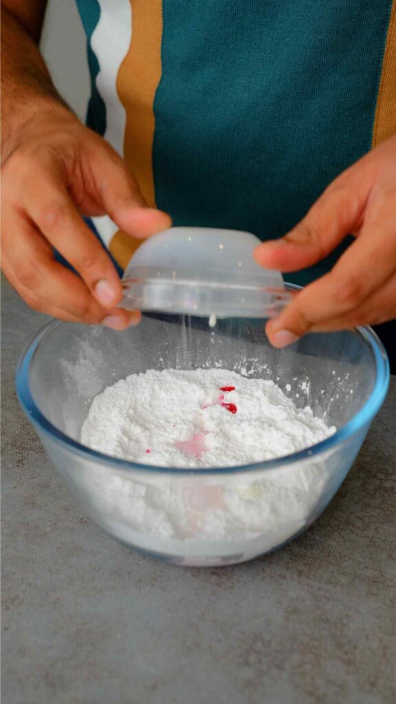 icing sugar, rose syrup, and milk in a mixing bowl