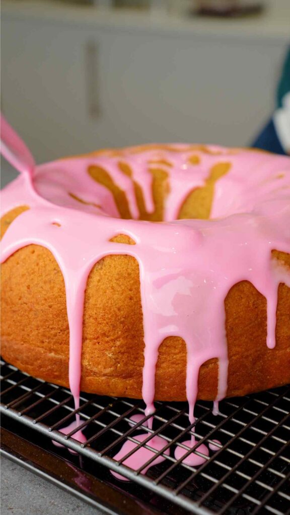 pouring rose glaze over pistachio and rose bundt cake