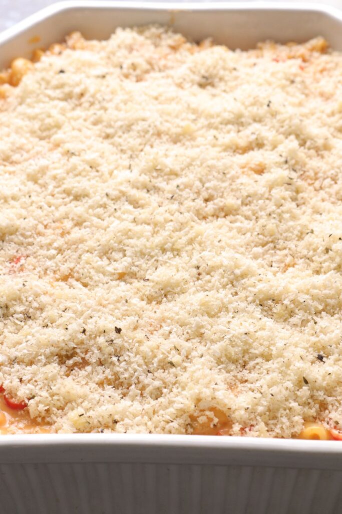 Breadcrumbs on top of mac and cheese in an oven tray