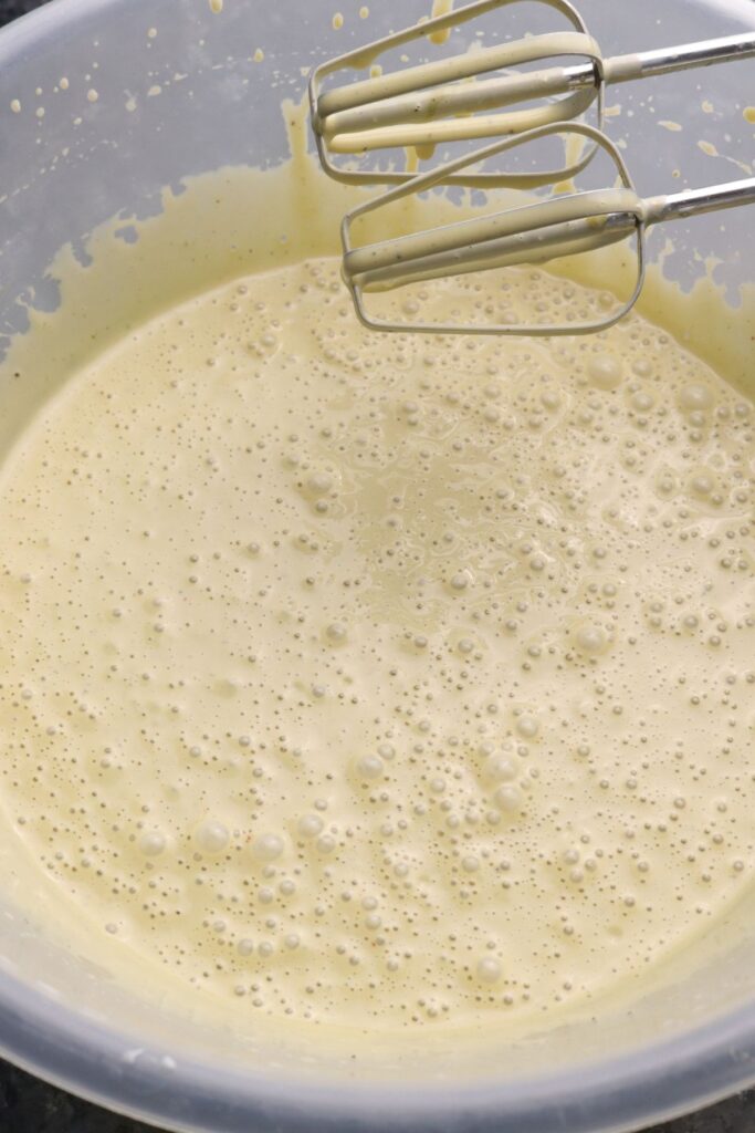 Whisking pistachio kulfi cheesecake filling