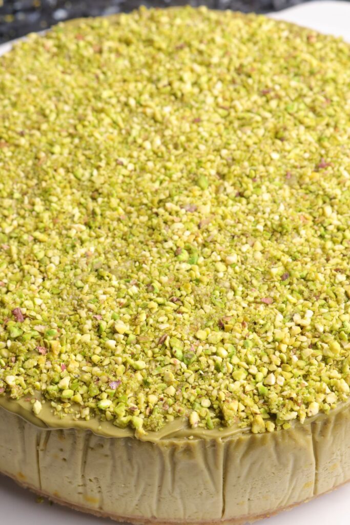 pistachios and pistachio cream on top of a pistachio cheesecake