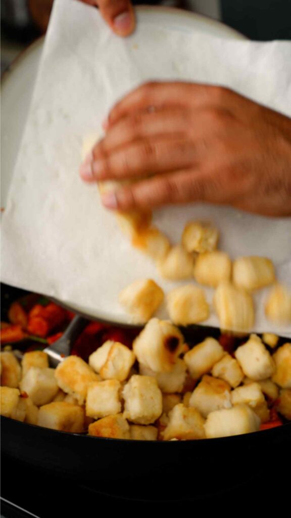 adding crispy tofu to the hot and sour vegetables
