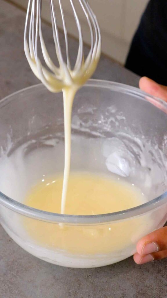 orange icing sugar glaze being whisked