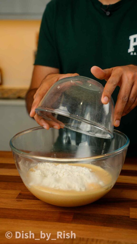 adding dry ingredients to wet mix in a mixing bowl