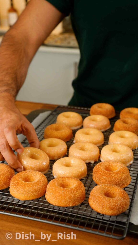 placing baked doughnuts on a wire rack