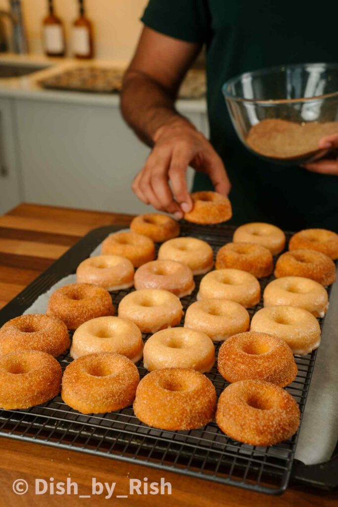 baked doughnuts being placed on a wire rack