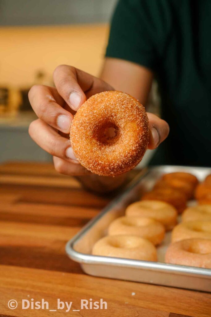 cinnamon sugar baked doughnut being held
