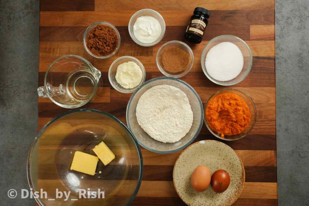 baked pumpkin spice doughnuts ingredients laid out on wooden board