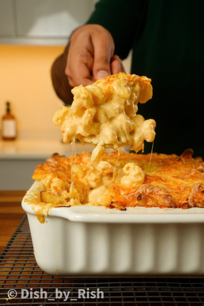 classic mac and cheese in a tray with a spoonful being lifted