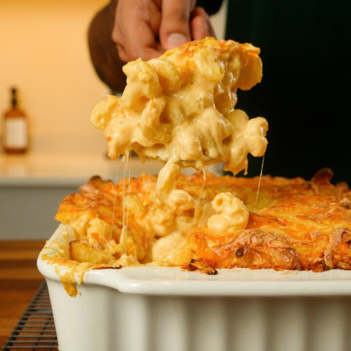 classic mac and cheese in a tray with a spoonful being lifted