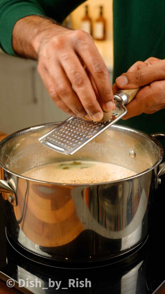 grating nutmeg into bechamel sauce