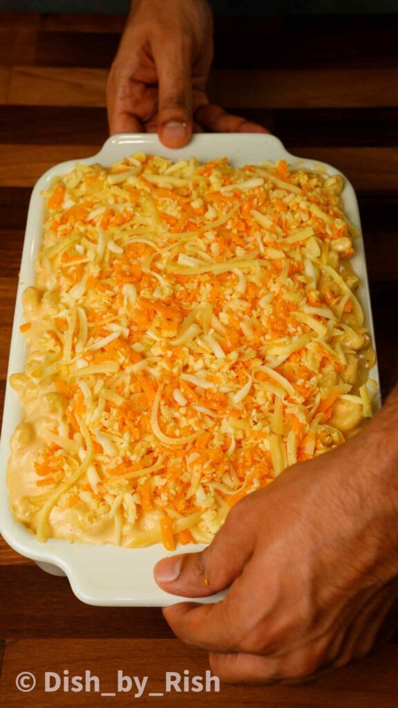 classic mac and cheese in an oven dish with grated cheeses on top