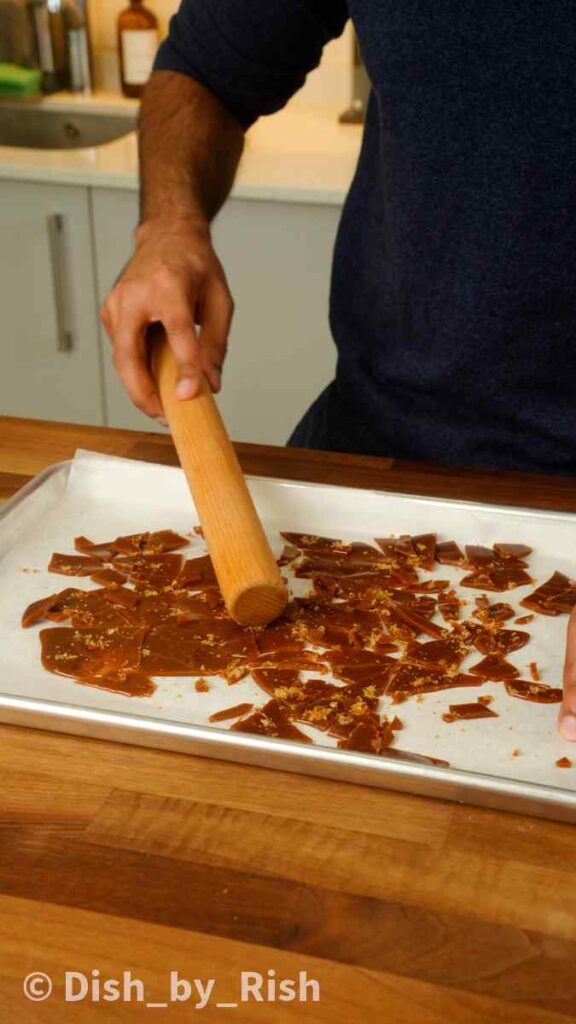 smashing toffee into pieces with a rolling pin