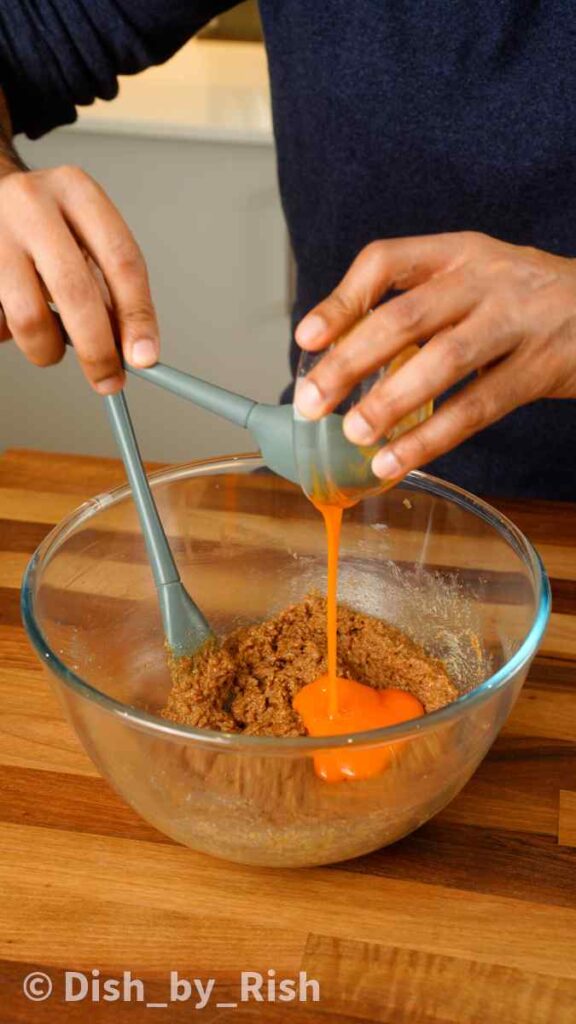 adding egg yolk to butter and sugar mixture