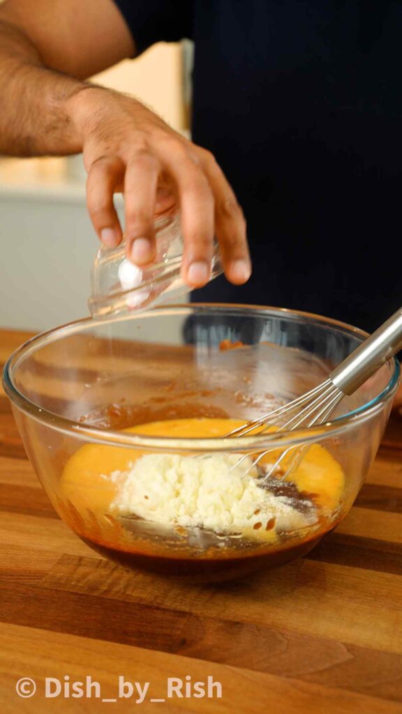 adding eggs and milk powder to mixing bowl