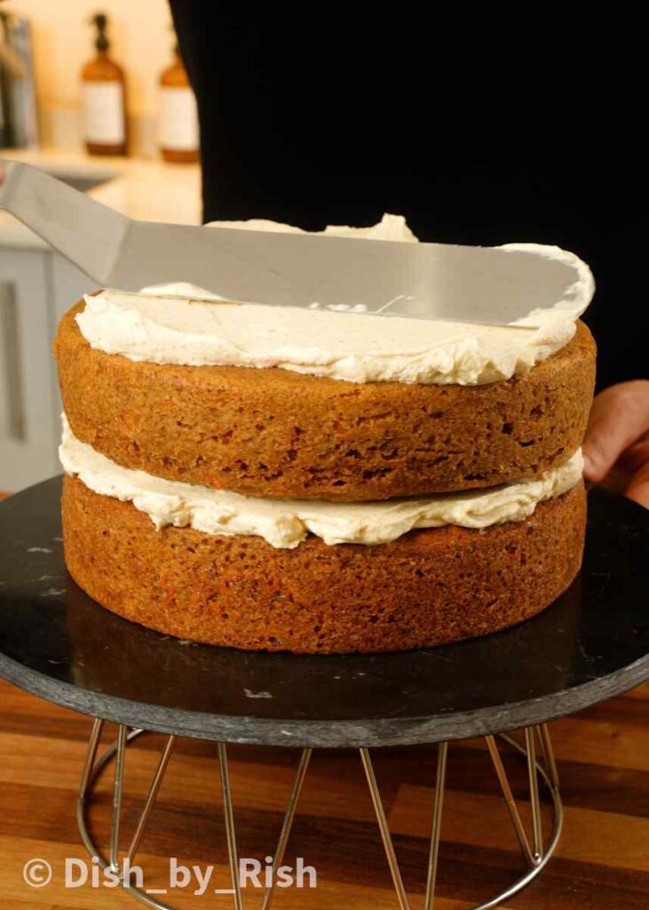 spreading frosting over second carrot cake layer