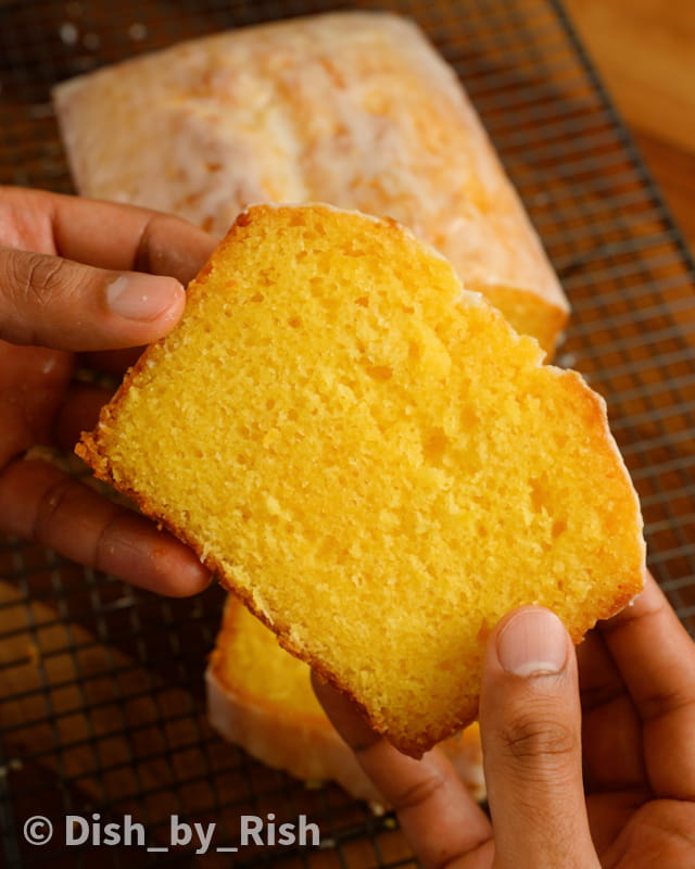 lemon drizzle loaf cake slice being held in hands