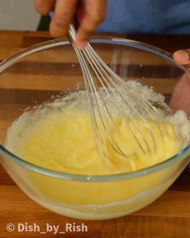 butter, oil, sugar, and lemon zest being whisked in a mixing bowl